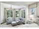 Bedroom sitting area with cozy armchairs, accent lighting and a large window view of the trees outside at 3114 Peachtree Ne Dr, Atlanta, GA 30305