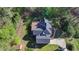 Stunning aerial view of home with deck, gray roof, a winding driveway, and lush, mature landscaping and trees at 3211 Thompson Mill Rd, Buford, GA 30519