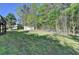 Green backyard with mature trees and a small storage shed at 3211 Thompson Mill Rd, Buford, GA 30519