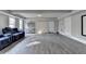 Open basement area showcasing plank flooring, natural light and a blue lounging sofa at 3211 Thompson Mill Rd, Buford, GA 30519