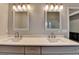 Bathroom featuring double vanity with granite countertop and two framed mirrors, and modern lighting at 3211 Thompson Mill Rd, Buford, GA 30519