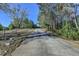 Long asphalt driveway leading up to a home surrounded by trees and foliage in the background at 3211 Thompson Mill Rd, Buford, GA 30519