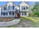 Charming two-story home with light siding, dark shutters, front yard and an attached garage at 3211 Thompson Mill Rd, Buford, GA 30519