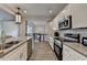 Modern kitchen design with stainless steel appliances, white cabinetry, and an open view to the upper floor at 3211 Thompson Mill Rd, Buford, GA 30519