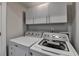 This laundry room features a white washer and dryer and white cabinets at 3211 Thompson Mill Rd, Buford, GA 30519