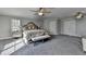 Spacious main bedroom featuring a bed, bench seat, carpet, and two entry doors at 3211 Thompson Mill Rd, Buford, GA 30519
