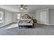 Spacious main bedroom with a large bed, bench seat, neutral color palette, and ample natural light at 3211 Thompson Mill Rd, Buford, GA 30519