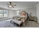 Main bedroom features a large bed, bench seat, large windows, carpet and a ceiling fan at 3211 Thompson Mill Rd, Buford, GA 30519