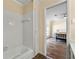 Bathroom with white tiled shower and bath and view into the bedroom at 5400 Roswell Rd # J2, Atlanta, GA 30342