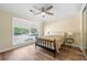 Bright bedroom features a large window overlooking the outside with a ceiling fan, and wood flooring at 5400 Roswell Rd # J2, Atlanta, GA 30342