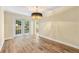 Inviting dining room with wood-look flooring, a stylish chandelier, and glass doors leading to an outdoor area at 5400 Roswell Rd # J2, Atlanta, GA 30342