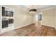 Elegant dining room featuring wood-look flooring, a modern chandelier, and an open view into the adjacent kitchen at 5400 Roswell Rd # J2, Atlanta, GA 30342