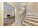 Elegant foyer featuring a gracefully curved staircase with a wrought iron railing and an adjacent living area with a fireplace at 5400 Roswell Rd # J2, Atlanta, GA 30342