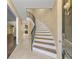 Elegant foyer showcasing a gracefully curved staircase with a wrought iron railing and neutral-toned walls with beautiful tile flooring at 5400 Roswell Rd # J2, Atlanta, GA 30342