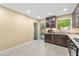 Well-lit kitchen featuring granite countertops, dark wood cabinetry, tile flooring, and stainless steel appliances at 5400 Roswell Rd # J2, Atlanta, GA 30342