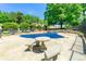 Community pool with table and chairs, surrounded by green trees and metal fence at 5400 Roswell Rd # J2, Atlanta, GA 30342