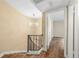A staircase leading to the upper level, illuminated by a chandelier, with wood floors and a landing to another room at 5400 Roswell Rd # J2, Atlanta, GA 30342