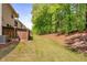 A view of a spacious backyard with lush green grass and a tall tree line that provides privacy at 1983 Silver Birch Se Dr, Smyrna, GA 30080