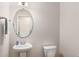 Neat half bathroom featuring a pedestal sink, an oval mirror, and toilet at 1983 Silver Birch Se Dr, Smyrna, GA 30080