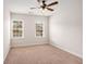 Cozy bedroom with neutral carpet, a ceiling fan, and two windows overlooking neighborhood homes at 1983 Silver Birch Se Dr, Smyrna, GA 30080