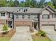 Beautiful brick and stone townhome exterior with two-car garage, manicured landscaping, and inviting entrance at 1983 Silver Birch Se Dr, Smyrna, GA 30080