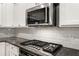 Kitchen showcasing a stainless steel microwave over gas range and white subway tile backsplash at 1983 Silver Birch Se Dr, Smyrna, GA 30080