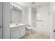 White bathroom features a shower and tub combination, single sink vanity and tile floors at 3858 Vineyards Lake Nw Cir # U-19, Kennesaw, GA 30144