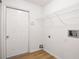 A bright laundry room features a white door, overhead shelving, and hookups for laundry machines at 3858 Vineyards Lake Nw Cir # U-19, Kennesaw, GA 30144