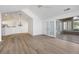 Open-concept living area with wood floors, vaulted ceiling, and access to a sunroom, ideal for modern living at 3858 Vineyards Lake Nw Cir # U-19, Kennesaw, GA 30144