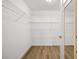 Bright walk-in closet featuring hardwood floors, wire shelving and convenient mirror at 3858 Vineyards Lake Nw Cir # U-19, Kennesaw, GA 30144