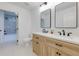 Bathroom featuring double sinks, modern mirrors, and a door to a tiled shower at 505 Cedar Creek Nw Rd, Cartersville, GA 30121
