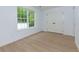 Bedroom featuring wood-look floors, white walls, natural light from window, and a double door closet at 505 Cedar Creek Nw Rd, Cartersville, GA 30121