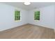 Bright bedroom featuring wood-look flooring, white walls, and natural light from two windows with views at 505 Cedar Creek Nw Rd, Cartersville, GA 30121