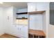 Bright storage area with white cabinets, wooden shelves, and bench seating at 505 Cedar Creek Nw Rd, Cartersville, GA 30121
