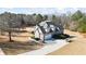 Aerial view of the house showcasing its well-maintained lawn, mature trees, and a spacious driveway at 135 Antoinette Ave, Mcdonough, GA 30252