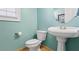Powder room featuring a pedestal sink, toilet, and neutral wall paint at 135 Antoinette Ave, Mcdonough, GA 30252
