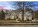 Charming brick home with a manicured front yard, mature trees, and a beautifully designed roofline at 135 Antoinette Ave, Mcdonough, GA 30252
