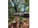 Wide angle showing the backyard with two sheds, a makeshift gym, and overgrown trees at 2245 Panstone Sw Dr, Marietta, GA 30060