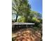 View of the home's overgrown backyard with an open shed and abundant foliage at 2245 Panstone Sw Dr, Marietta, GA 30060