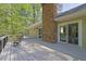 Back deck overlooking the trees and large backyard featuring a brick chimney and access to the house at 115 Beechwood Trl, Roswell, GA 30075