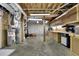 Large unfinished basement with exposed ceiling, concrete floor, water heater and work bench at 115 Beechwood Trl, Roswell, GA 30075