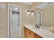Bathroom featuring floral wallpaper, a vanity with a sink, and a shower with glass doors at 115 Beechwood Trl, Roswell, GA 30075