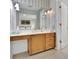 Bathroom with oak vanity and large mirror, complemented by striped walls and warm, inviting lighting at 115 Beechwood Trl, Roswell, GA 30075