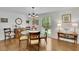 Elegant dining room features a glass table, decorative chandelier, wood floors, and large window overlooking the backyard at 115 Beechwood Trl, Roswell, GA 30075