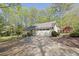 Inviting home with an attached two-car garage, long driveway, and lush greenery, creating a serene setting at 115 Beechwood Trl, Roswell, GA 30075