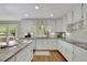 Well-lit kitchen features granite countertops, white cabinets, stainless appliances, and hardwood floors at 115 Beechwood Trl, Roswell, GA 30075