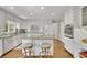 Well-lit kitchen boasts an island, stainless oven, white cabinetry, granite countertops and eat-in seating at 115 Beechwood Trl, Roswell, GA 30075