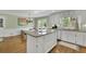 This bright, updated kitchen features an island, granite countertops, stainless appliances, and modern lighting at 115 Beechwood Trl, Roswell, GA 30075