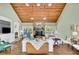 Open-concept living room with wood ceiling, stone fireplace, hardwood floors, built-in cabinetry, and abundant natural light at 115 Beechwood Trl, Roswell, GA 30075