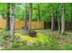 Secluded backyard area with trees, a fire pit, a bench, and a small table at 1270 Cameron Crk, Marietta, GA 30062